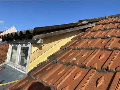Planche de rive neuve posée le long d'une lucarne